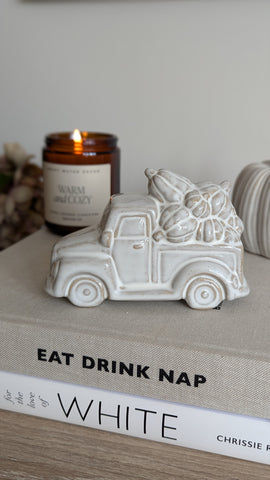 a natural, beige coloured glazed ceramic pick up truck carrying an array of pumpkins in the rear 